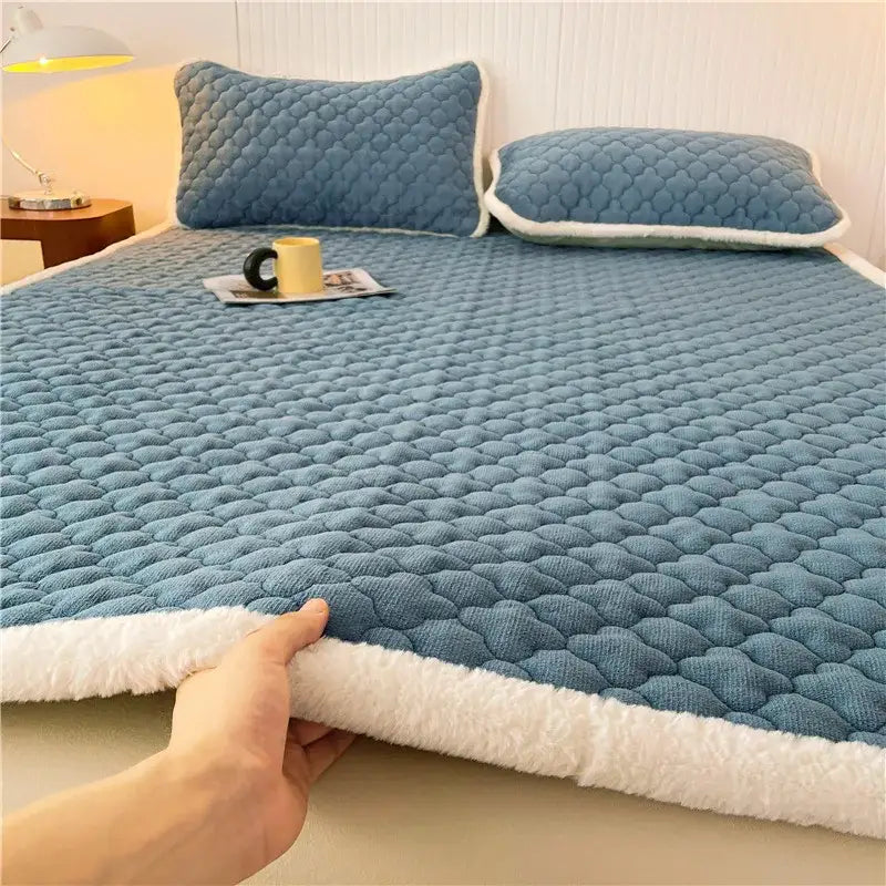 Blue quilted bed pad with white fleece trim on gray and white antibacterial milk velvet mattress for bedroom decorbites antibacterial milk use