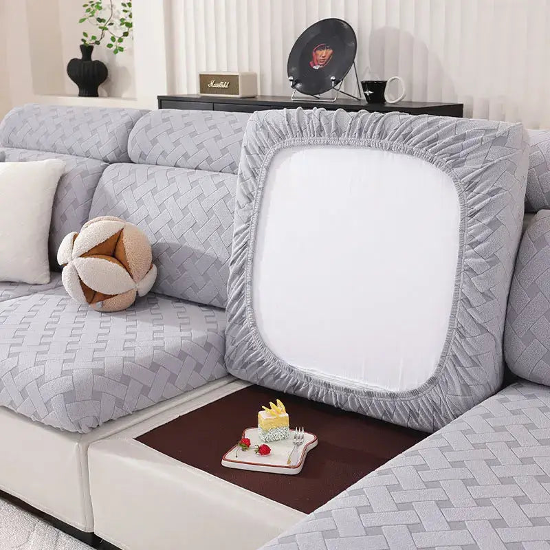 Gray and white woven elastic sofa slipcover with elasticized edges and central panel for living room sofa protection