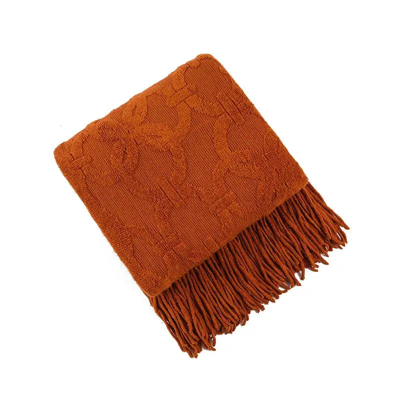 A warm terracotta knit blanket with textured floral pattern and fringe for knit blanket sofa decorbites decor