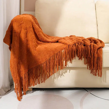 Warm orange knit blanket with textured cable pattern and long fringe for knit blanket sofa decorbites knit blanket decor