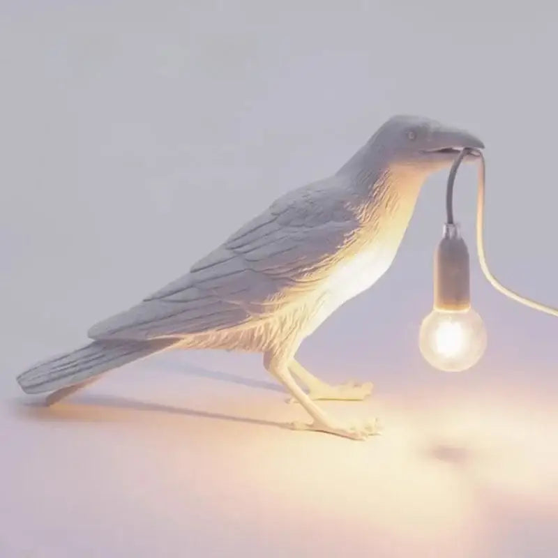 Gray ceramic lively bird resin table lamp featuring a raven holding a glowing bulb for bedroom decorbites lively bird