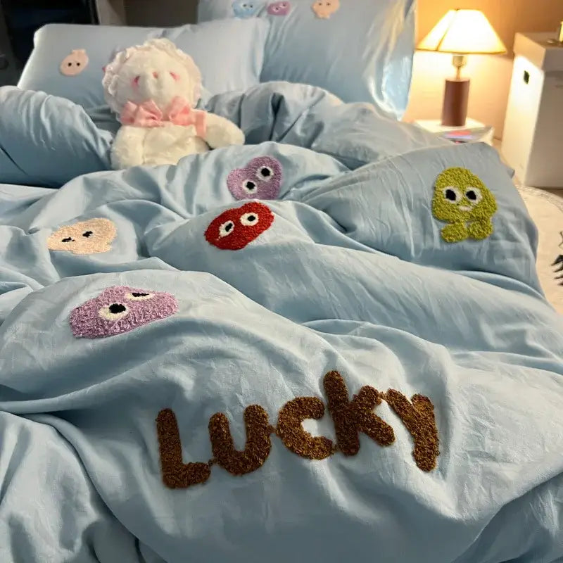 Light blue cotton cartoon towel bedding set with colorful fuzzy embroidered faces and lucky lettering for decorbites decor