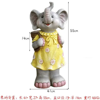A gray ceramic elephant garden decoration wearing a yellow floral dress and carrying a woven basket outdoors