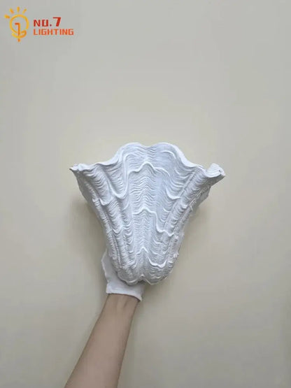White gypsum shell led wall lamp with intricately textured sculpted design ideal for bedroom sconce lighting