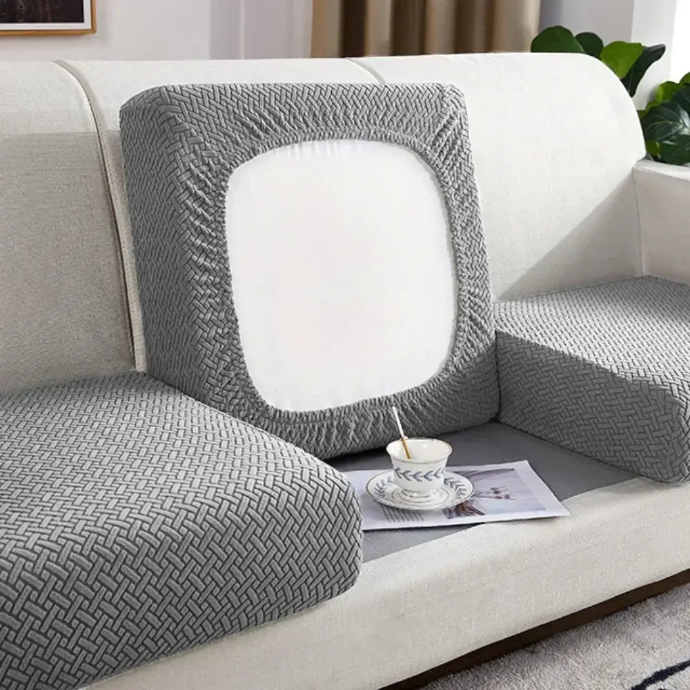 Gray herringbone stretch sofa seat cover featuring gray woven fabric with a white central panel for living room furniture protection