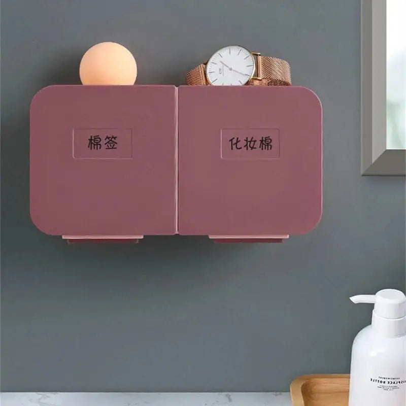 Pink dual-compartment wall-mounted organizer with labeled sections for cotton pads and makeup towels by decorbites cotton swab