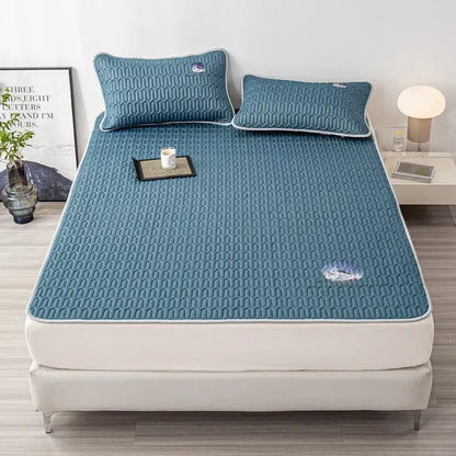 Teal quilted cooling latex bed mat with white piping and subtle embroidered cloud motifs in a bed mat set