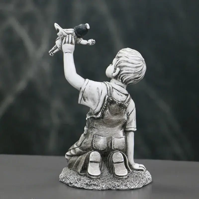 Gray resin super nurse angel boy statue in overalls kneeling and holding a doll for living room decor