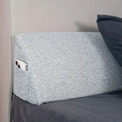 Gray textured memory foam bed wedge pillow with built-in pocket holding smartphone for bedroom mattress gap filler