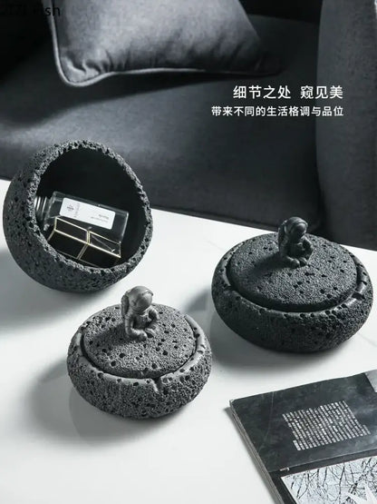 Gray volcanic stone cement astronaut ashtray featuring black lava rock texture and a miniature astronaut figurine for living room use