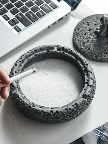 Gray volcanic stone cement astronaut ashtray with porous lava rock texture and astronaut figurine lid for living room use