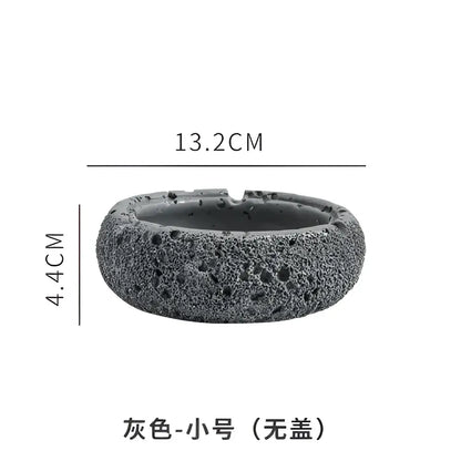 Gray volcanic stone cement astronaut ashtray with textured porous surface and rounded shape for living room use