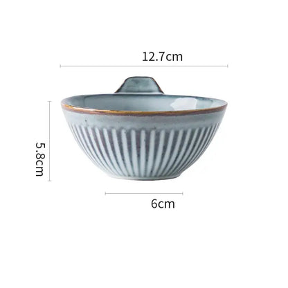 A light blue glazed ceramic bowl with vertical ridges and handle from gray and white striped ceramic wedding tableware set