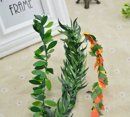 Three artificial leaf vine wreath garlands with green rounded leaves, pointed leaves, and autumn-colored paper leaves for decor