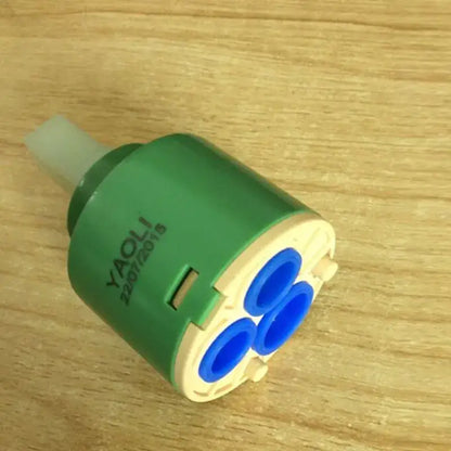 Green and beige 40mm ceramic faucet cartridge with three blue internal openings for kitchen valve replacement