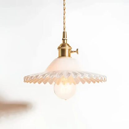 Delicate brass pendant light with scalloped translucent glass shade and exposed bulb on decorbites copper base glass fixture