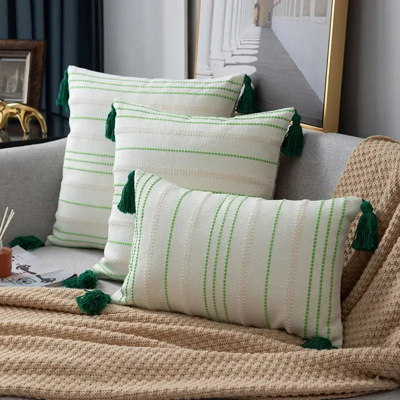 Three cream cushion covers with green black stripe crochet pattern and dark green tassels for living room decor