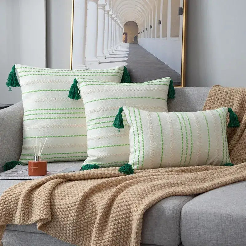 Three cream throw pillows with green black stripe crochet cushion cover and matching green tassels for living room decor