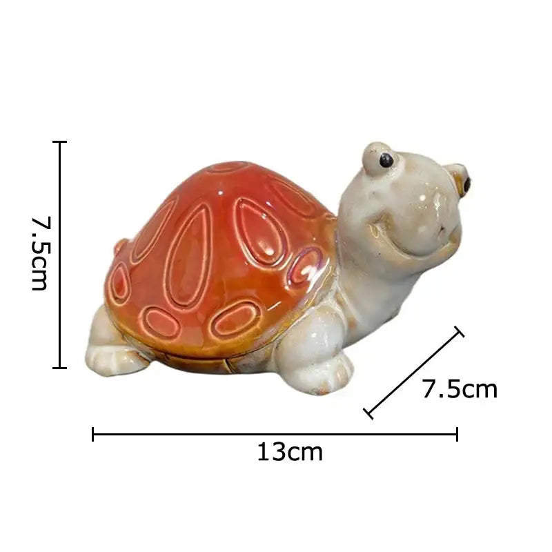 A charming ceramic turtle statue desk decoration with a glossy orange shell and cream body measuring 13cm long
