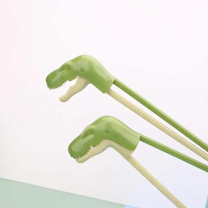 Green dino chopsticks kids training set with dinosaur shaped green tips and light-colored handles by decorbites