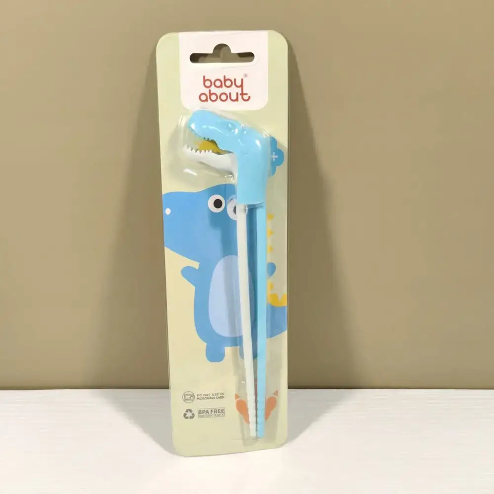 Light blue dinosaur-shaped baby feeding utensils in baby about package for kids training with decorbites dino chopsticks
