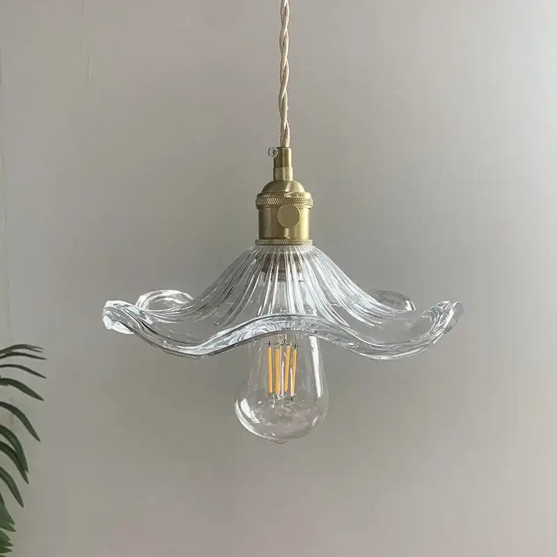 Clear glass pendant light with fluted petal shade and polished copper hardware for dining room illumination
