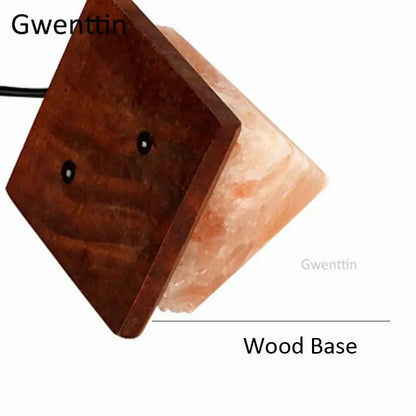 A gwenttin crystal usb salt night light with warm pinkish-orange translucent body on dark wooden base for decorbites decor