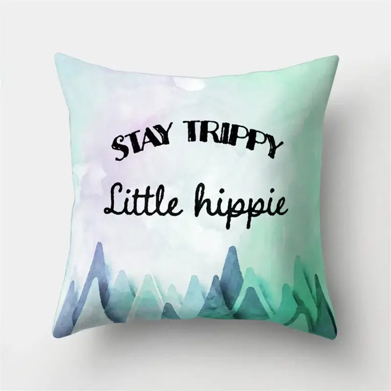 A soft mint green throw pillow with a watercolor mountain design and stay trippy little hippie text for green tropical leaves forest decorbites home decor