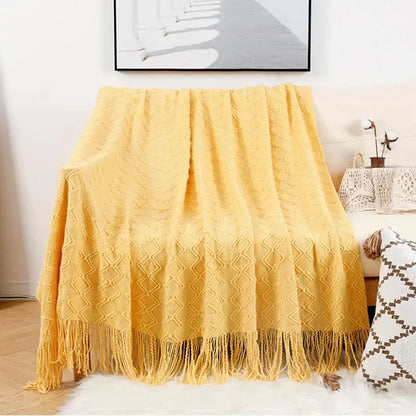 A cozy mustard-yellow knitted throw blanket with diamond texture and fringe shown alongside decorbites grey nordic waffle knit bedroom throw