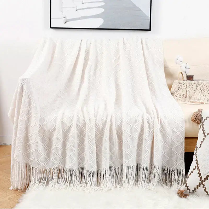 Cream-colored knitted throw blanket with diamond pattern and tassels in decorbites grey nordic waffle knit bedroom decor