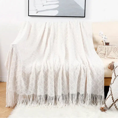 Cream-colored knitted throw blanket with diamond pattern and tassels in decorbites grey nordic waffle knit bedroom decor