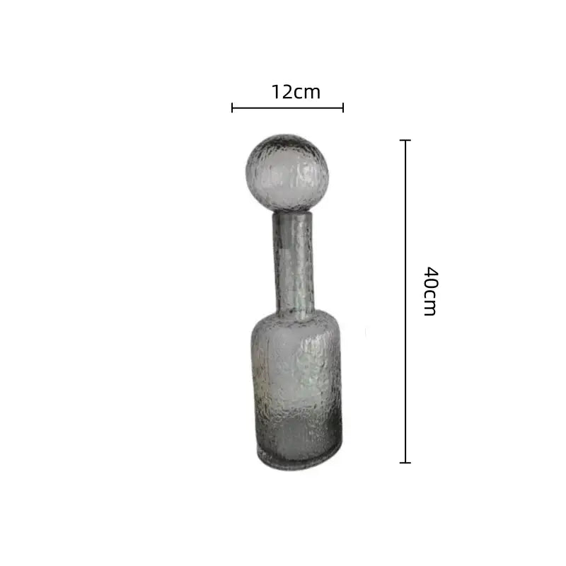 A translucent grey round glass decanter with hammer lid stopper and textured frosted finish for living room decorbites grey round