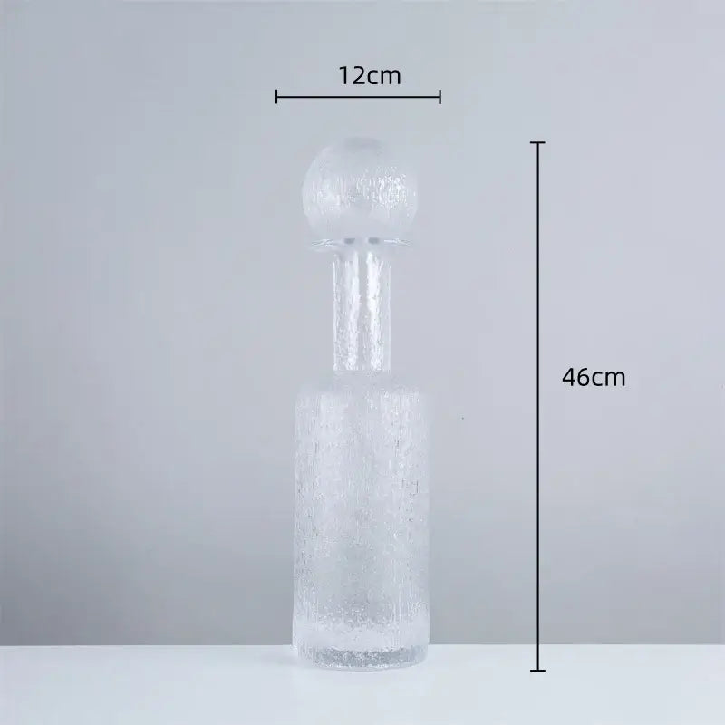 A tall frosted grey round glass decanter with textured surface and hammer lid stopper for living room decorbites decor