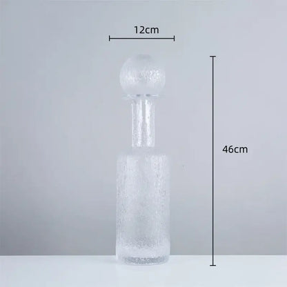 A tall frosted grey round glass decanter with textured surface and hammer lid stopper for living room decorbites decor