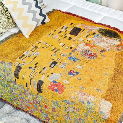 Vibrant yellow woven bedroom blanket featuring gustav klimt the kiss art pattern with intricate floral designs and red fringe edges