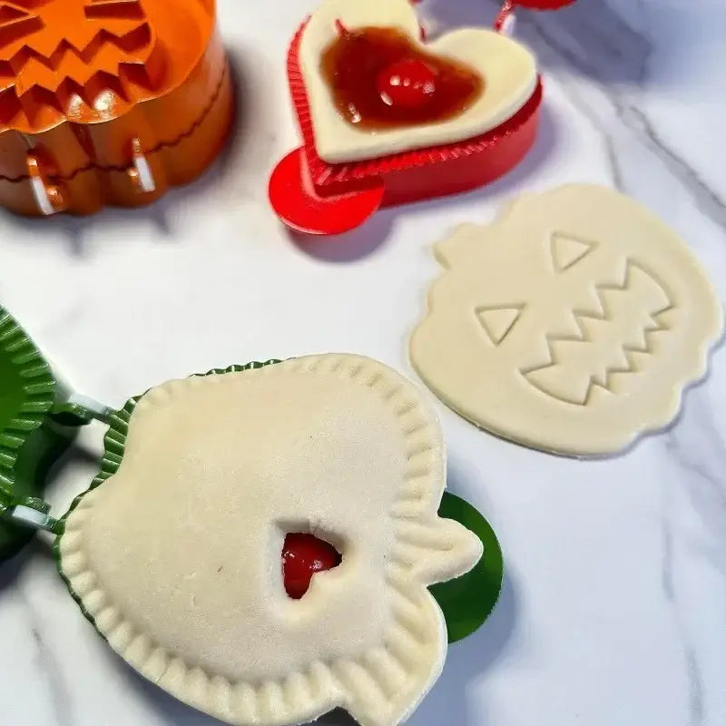 Orange pumpkin-shaped hand pie mold with white handles from halloween pie molds set for kitchen baking tools