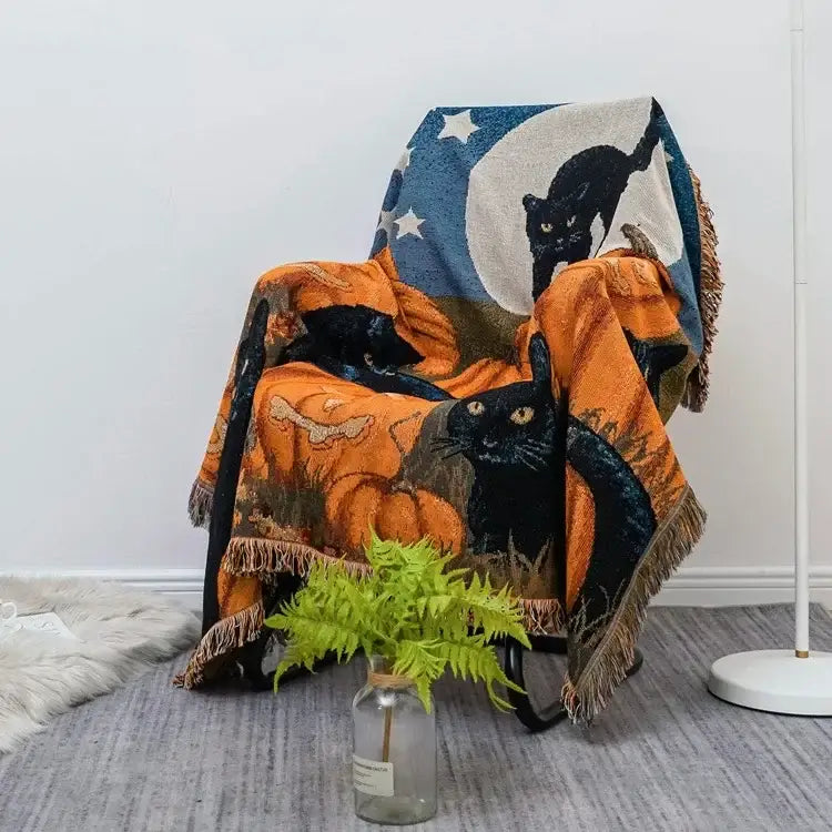Halloween style tassel throw blanket featuring black cats pumpkins and crescent moon on dark blue background with stars