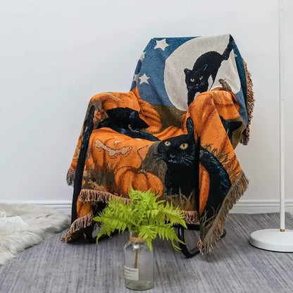Halloween style tassel throw blanket featuring black cats pumpkins and crescent moon on dark blue background with stars
