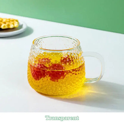 Clear textured 400ml hammer pattern glass mug with colorful handle filled with layered yellow and red liquid