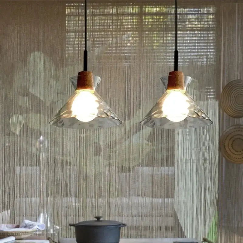 Hammered clear glass pendant light with kitchen cork accents and wooden details hanging from black cords decorbites clear glass pendant