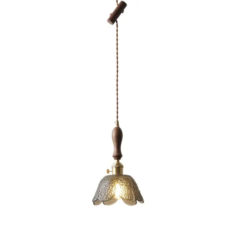 A warm-toned hammered gray glass led pendant lamp with dark wood handle and brass accents for living room lighting