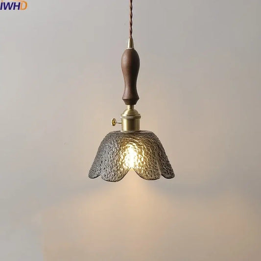 A warm-toned hammered gray glass led pendant lamp with dark wood handle and brass accents for living room lighting
