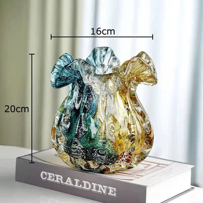 A hand blown glass vase with colorful flower edge features swirling teal and amber hues and a fluted rim for dining room use