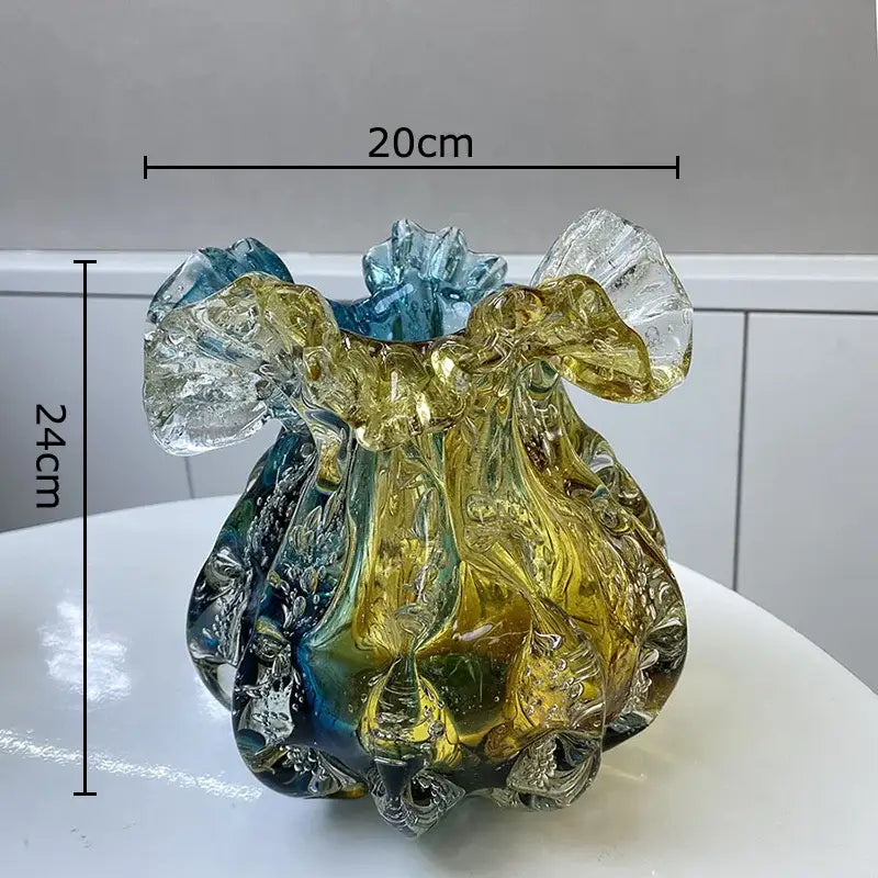 A hand blown glass vase with colorful flower edge featuring swirling amber teal hues and a ruffled blue rim for dining room
