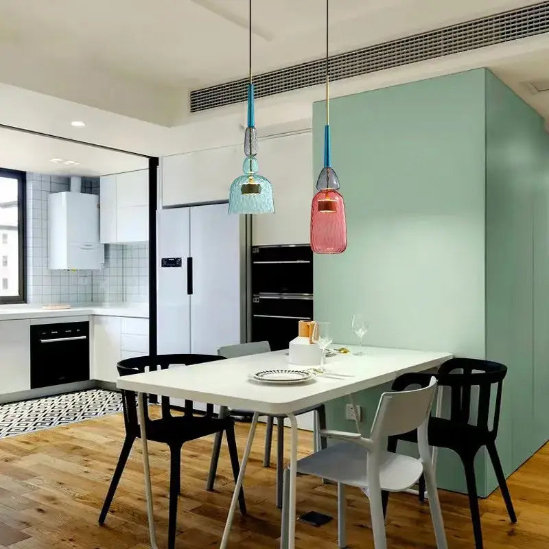 Two hanging pendant lights with blue and pink hand-blown decorbites candy glass chandelier above white dining table