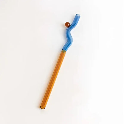 A sleek hand blown colorful glass straw with a vibrant blue wavy top and amber base by decorbites glass straws
