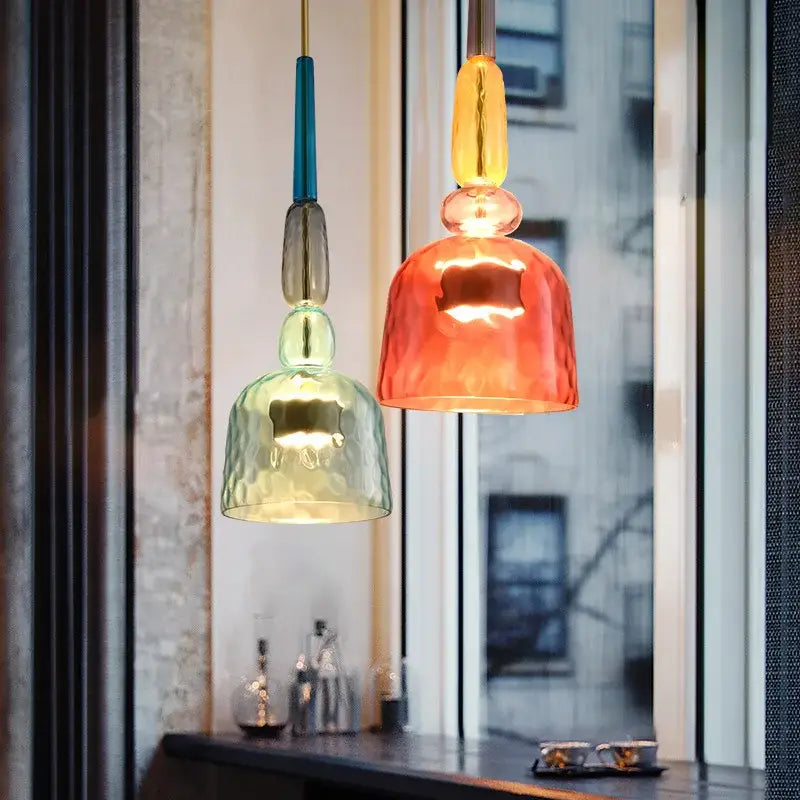 Two colorful hand blown textured glass pendant lights with metallic accents hang as kitchen accent lighting