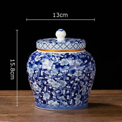 Hand-painted white porcelain tea canister with blue floral designs and a lattice-patterned lid for kitchen storage