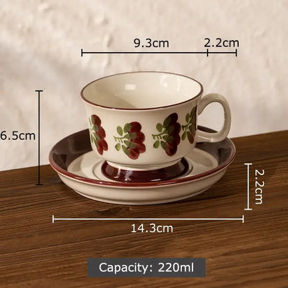 A hand-painted decorbites flowers pattern ceramic cup and saucer set in white with red and green floral design for dining room use