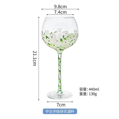 Hand painted glass goblet with white floral design pink and yellow accents 21.1cm tall 440ml capacity for dining decor